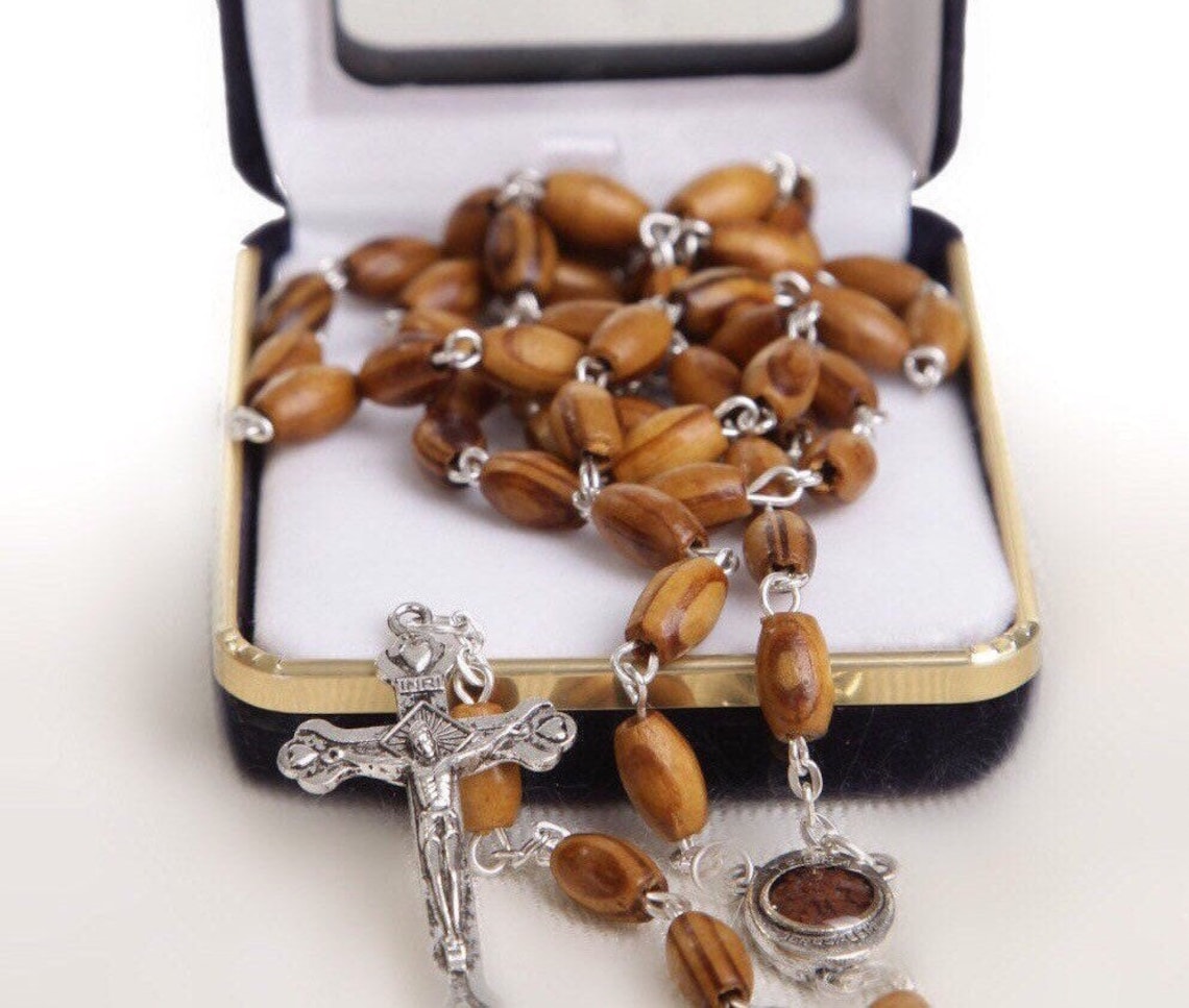 Holy Land Olive Wood Rosary with a Silver Cross and contains Holy Soil from the Holy Land where Jesus walked inside a premium velvet box.