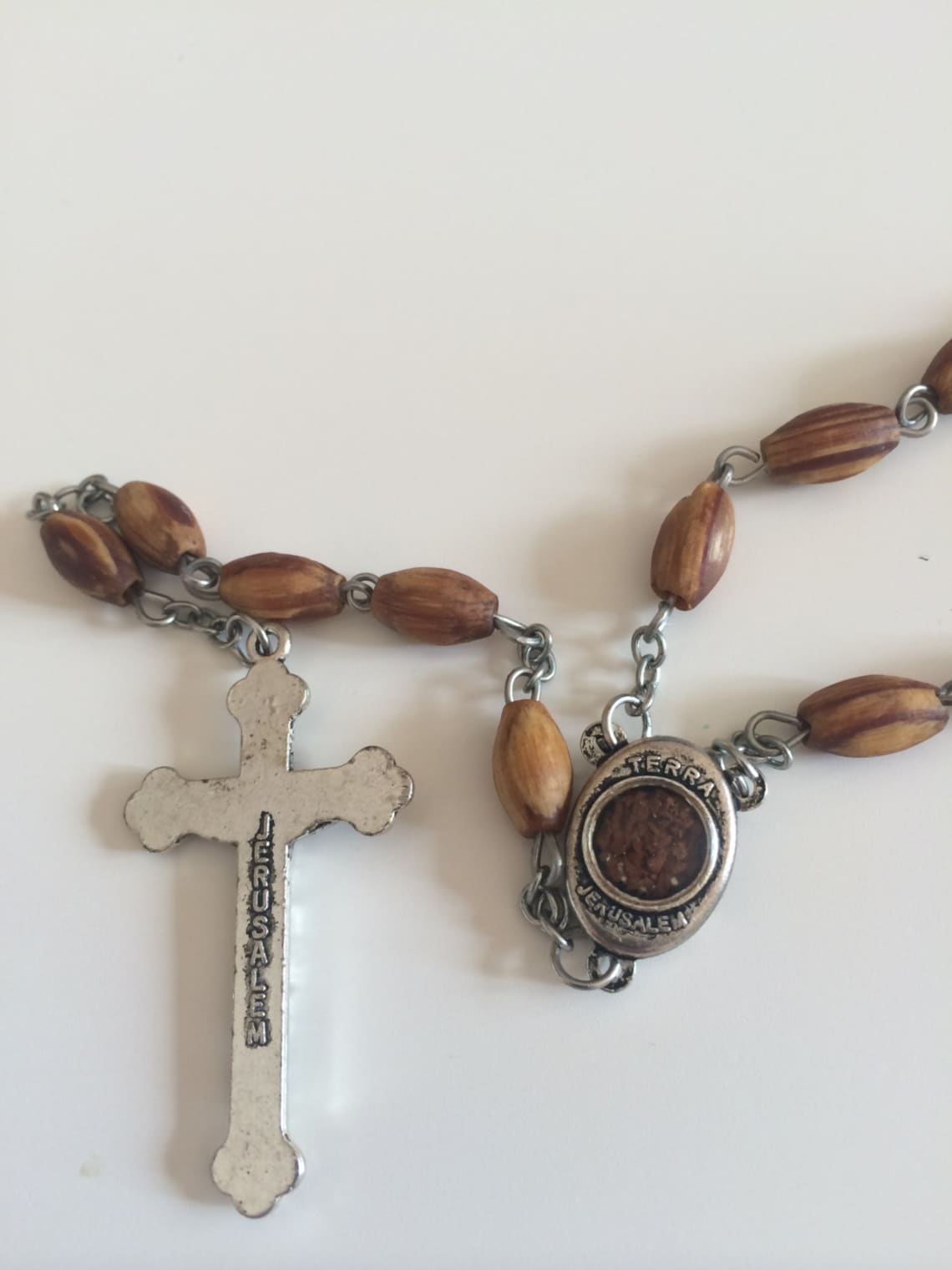 Holy Land Olive Wood Rosary with a Silver Cross and contains Holy Soil from the Holy Land where Jesus walked inside a premium velvet box.